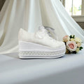 White  Bridal wedding shoe with platform and decorative elements on a light background