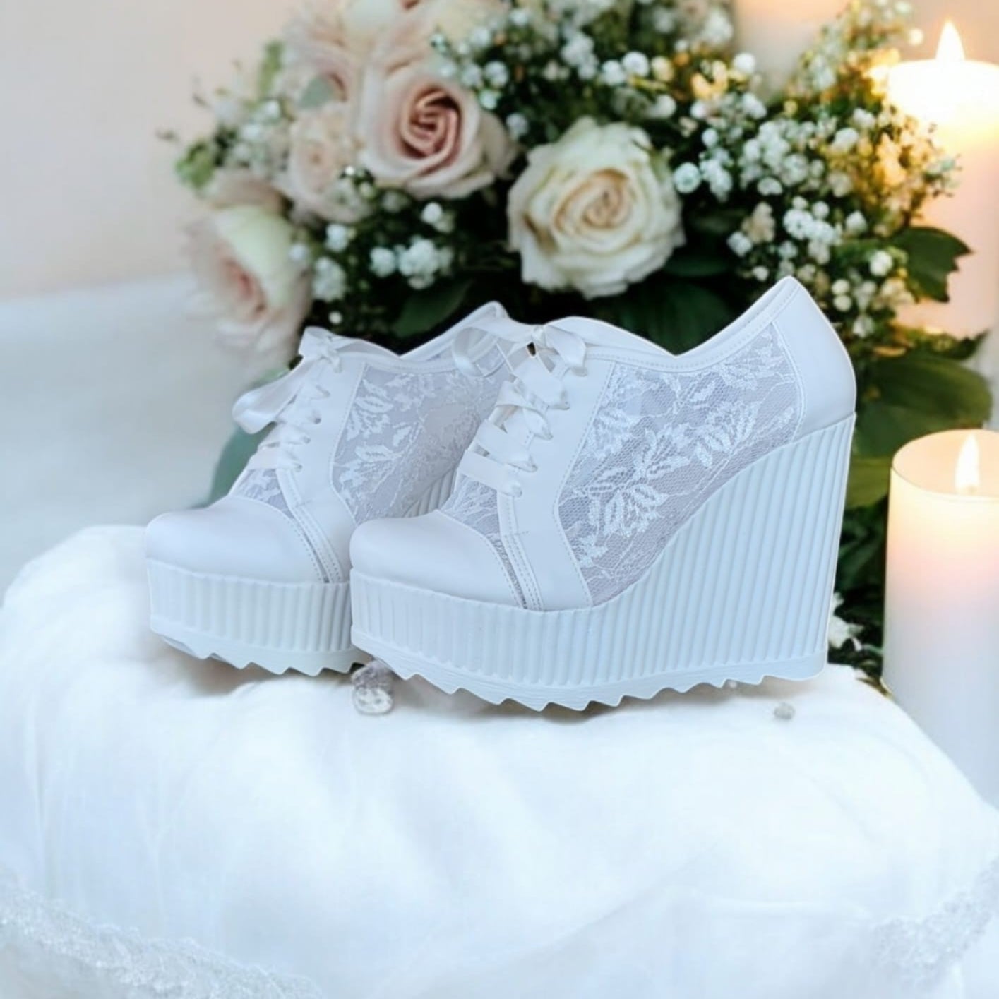 White lace wedges on a white surface with flowers 