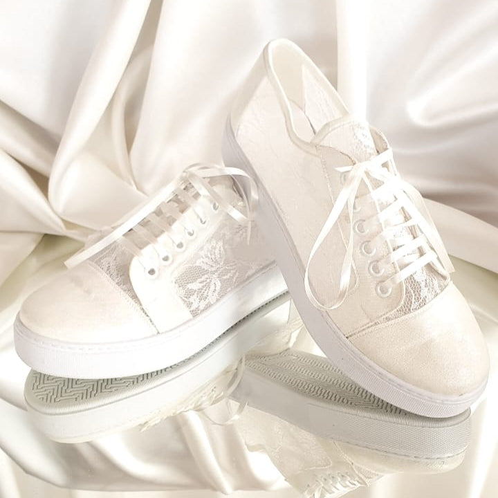 White sneakers on a soft, light fabric background