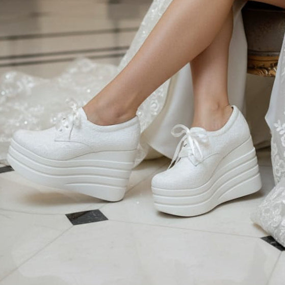 Bride wearing a white lace dress and Bridal Sneakers platform shoes 
