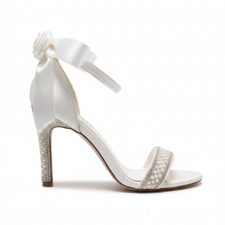 White high-heeled sandal with embellishments on a white background